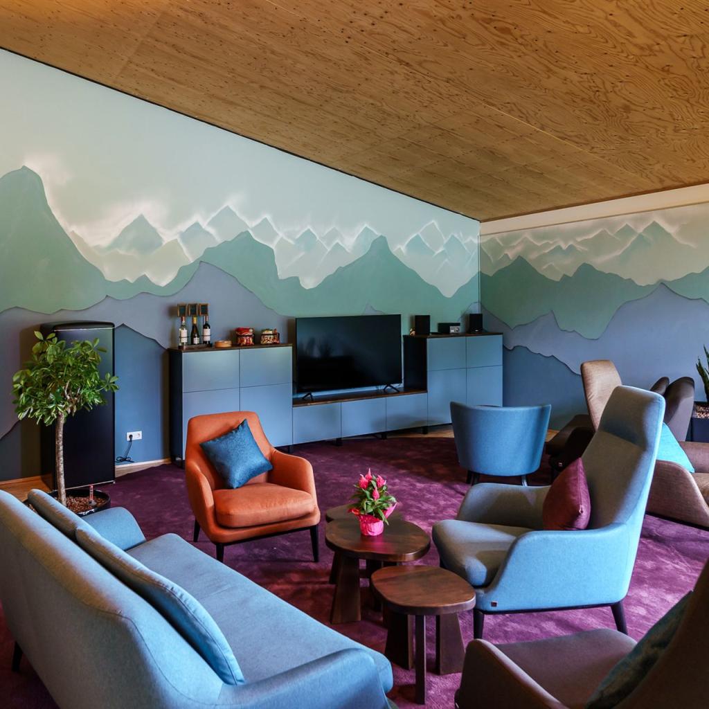 Das Bild zeigt das Kaminzimmer von oben. Man sieht das Zimmer mit Sesseln und der Tür.