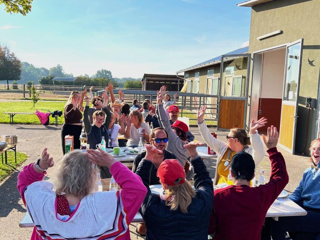 Das Bild zeigt eine jubelnde Menschengruppe auf Gut Aufeld