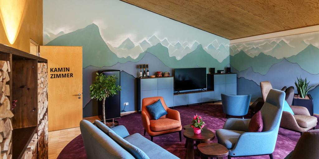 Das Bild zeigt das Kaminzimmer von oben. Man sieht das Zimmer mit Sesseln und der Tür.
